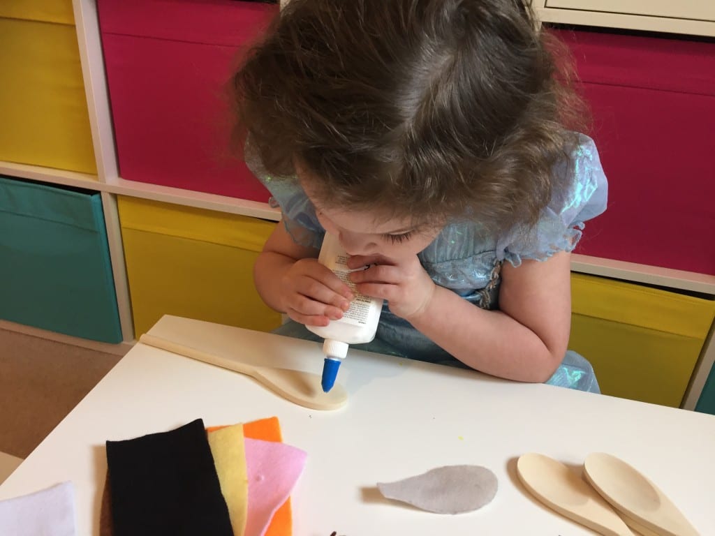 Isla glueing the felt onto her wooden spoon