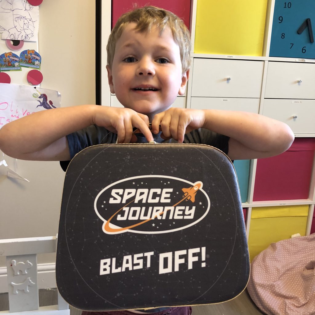 Oliver holding his new space journey suitcase