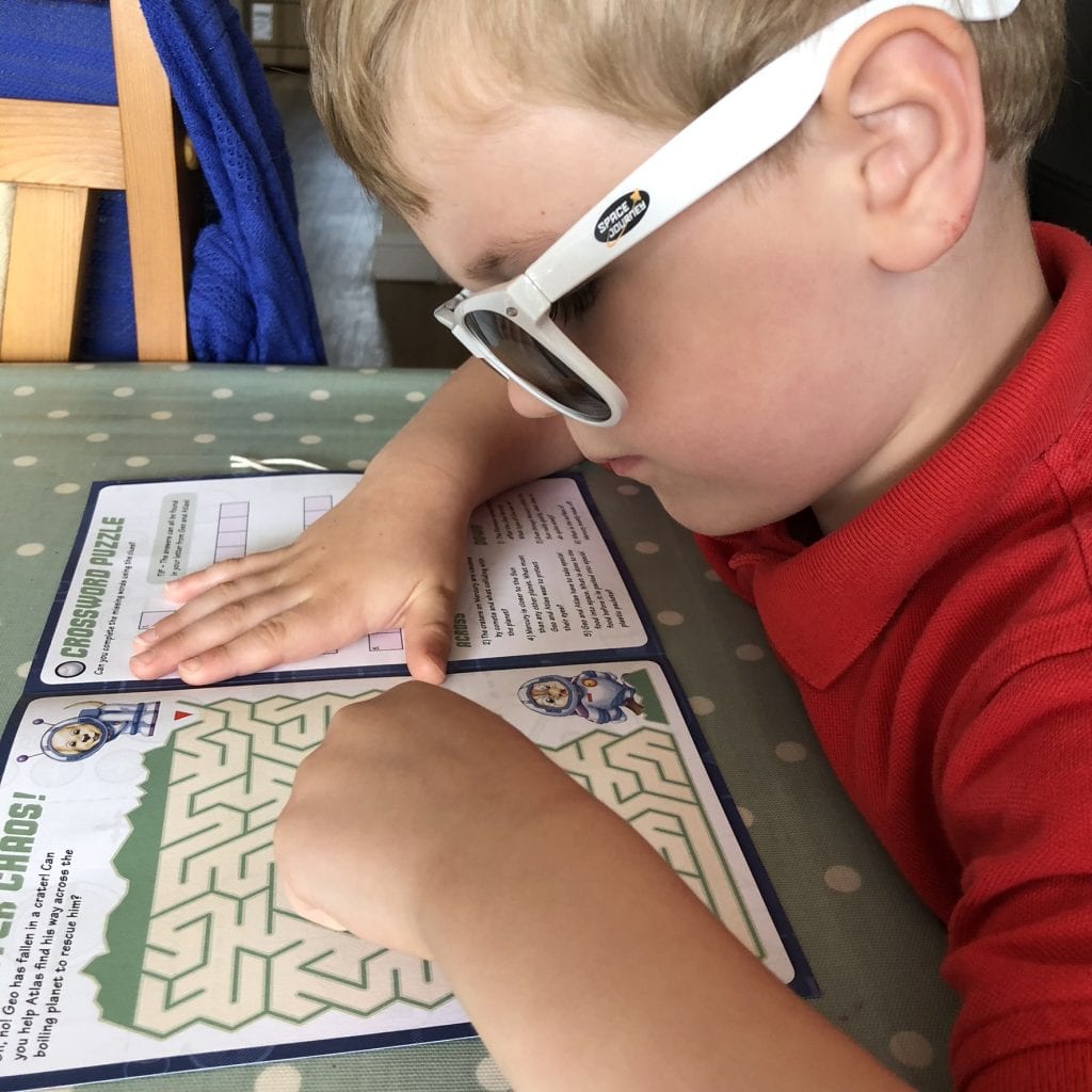 Oliver using the activity book from his Mecury pack.