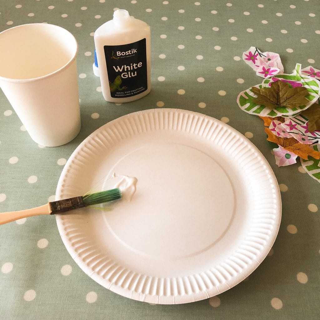 painting glue onto the paper plate