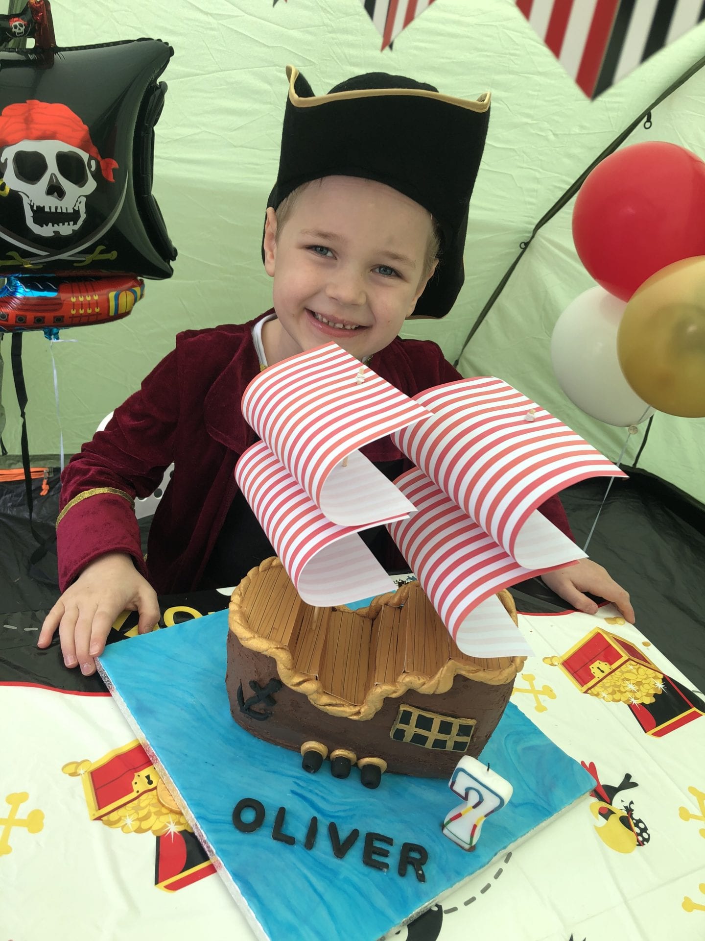 Oliver sat behind his pirate ship birthday cake