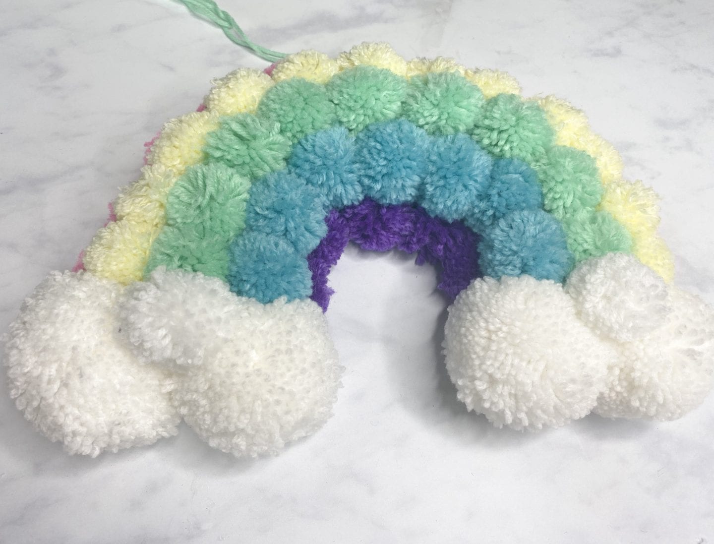 the finished rainbow pom pom wreath