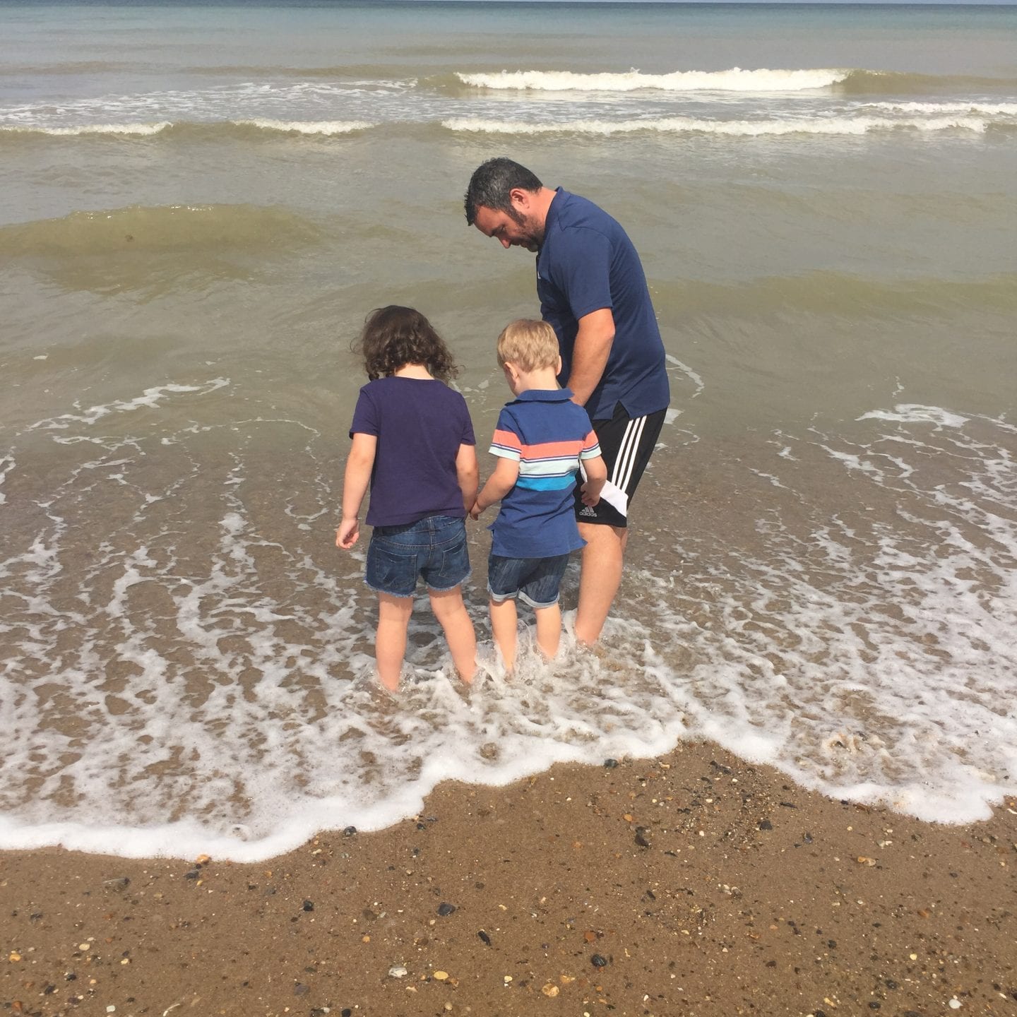 young family paddling in the sea