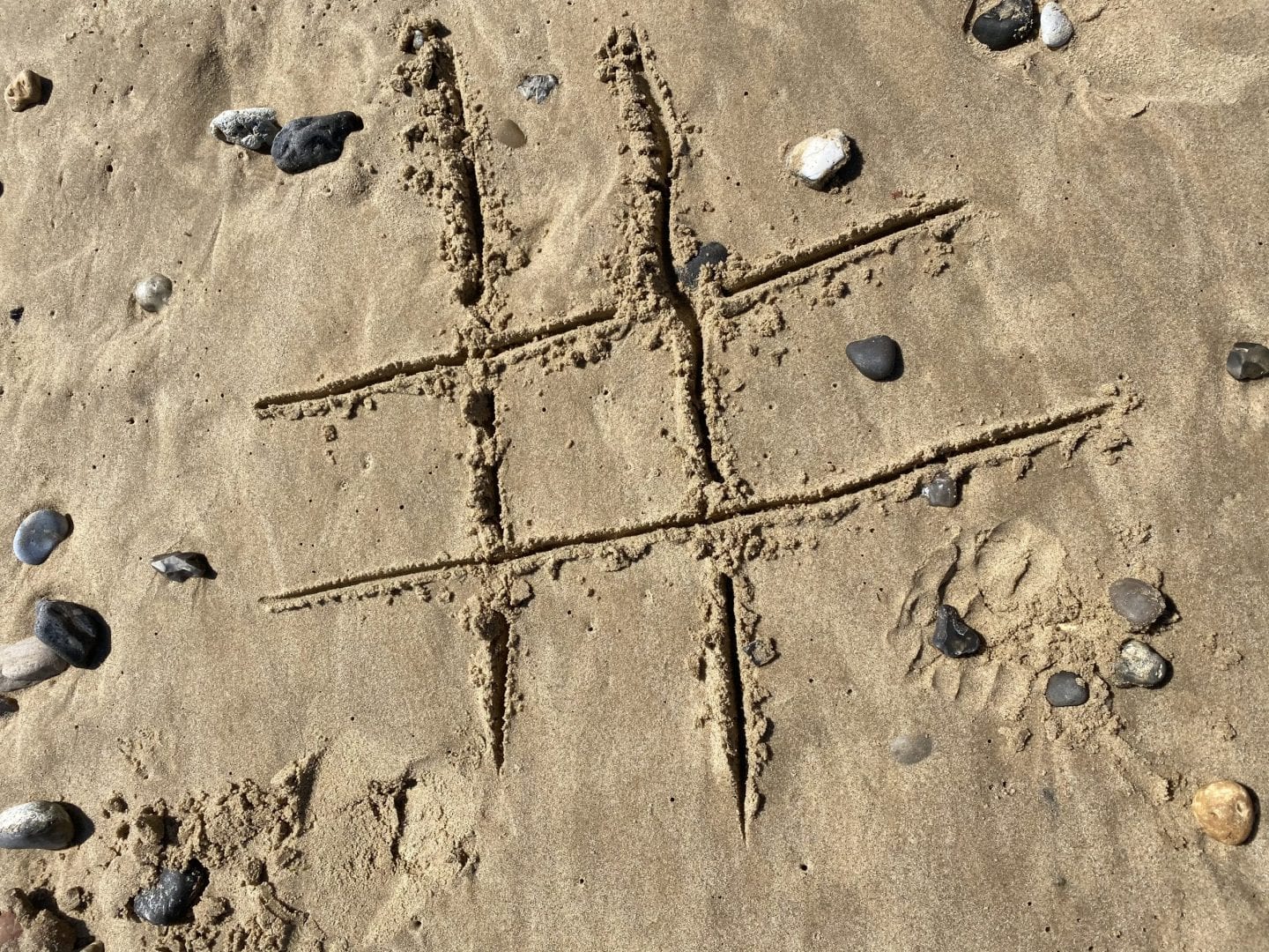 tic tac toe drawn in the sand