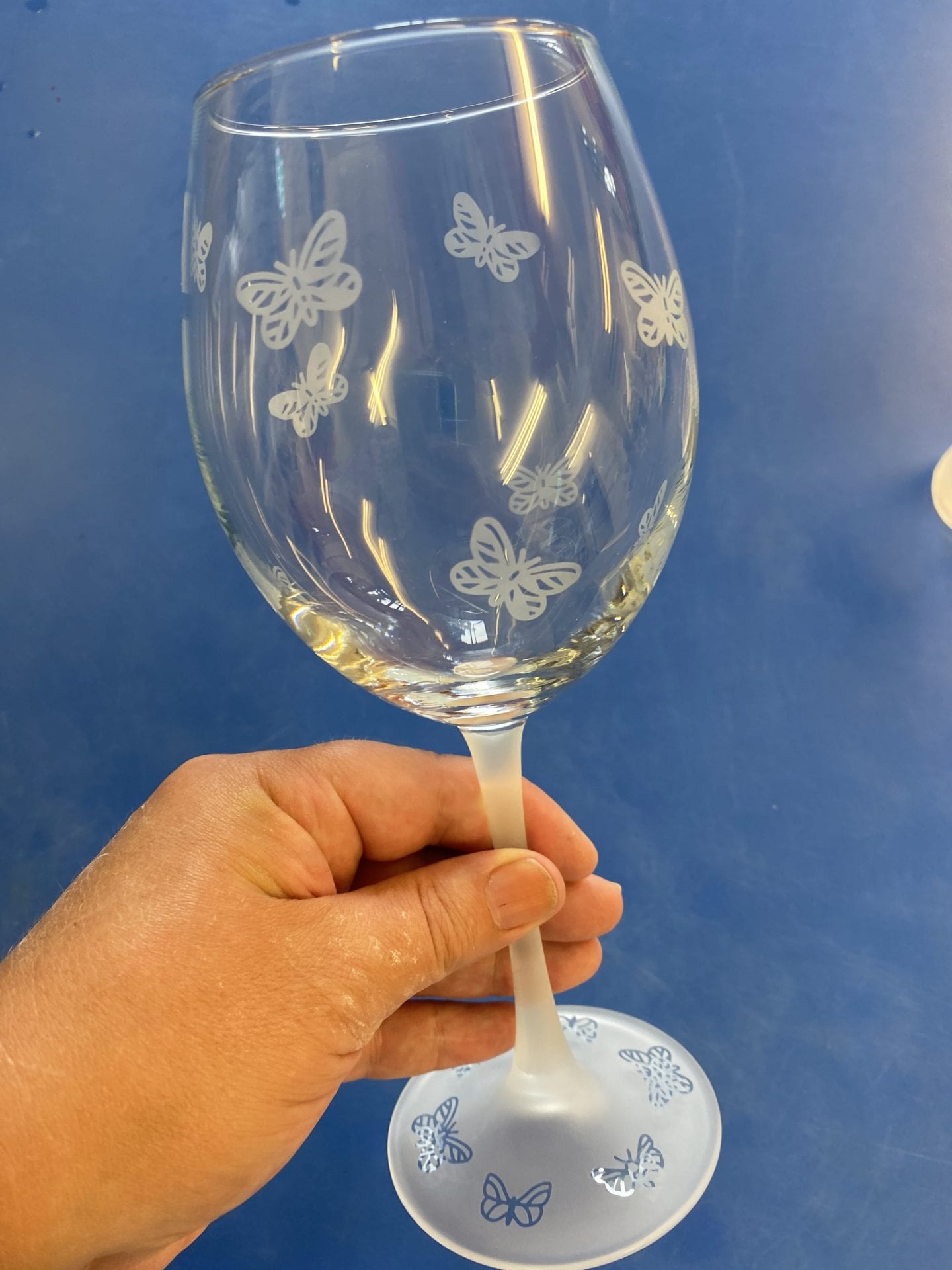 A wine glass with butterflies engraved on it