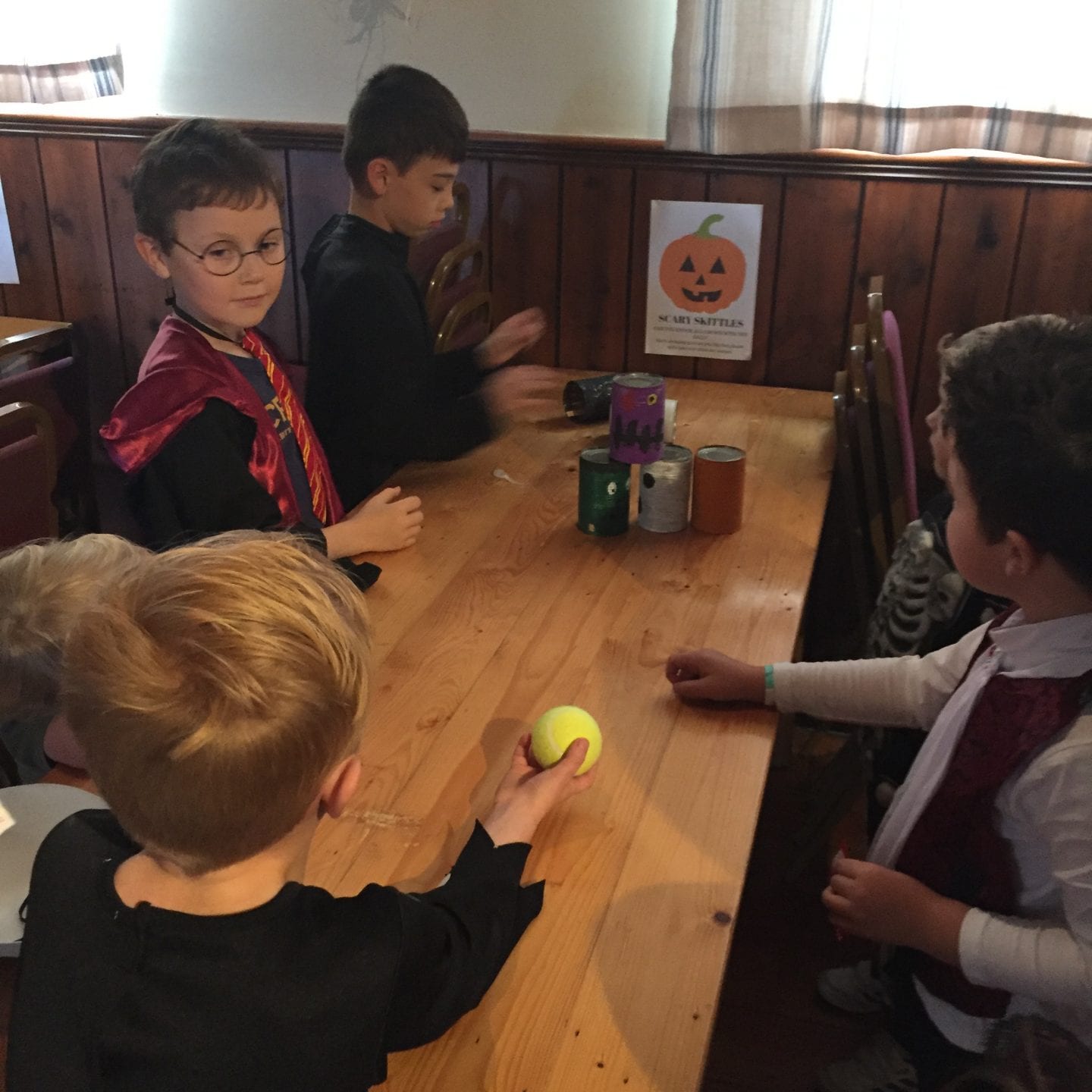 A group of young boys playing scary skittles