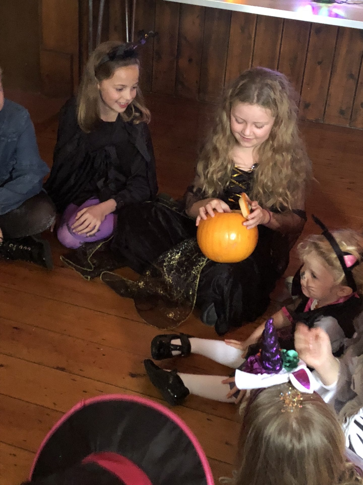 Some children sat on the floor playing 'pass the pumpkin'