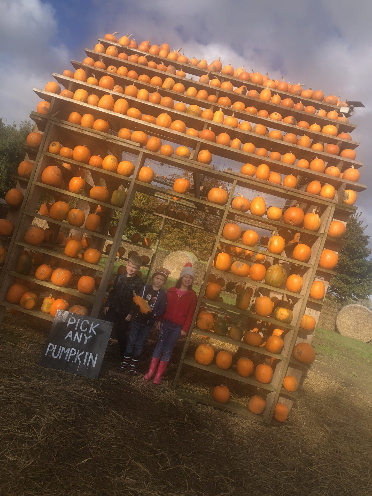 3 children standing in the entance of the 'Pumpkin House'