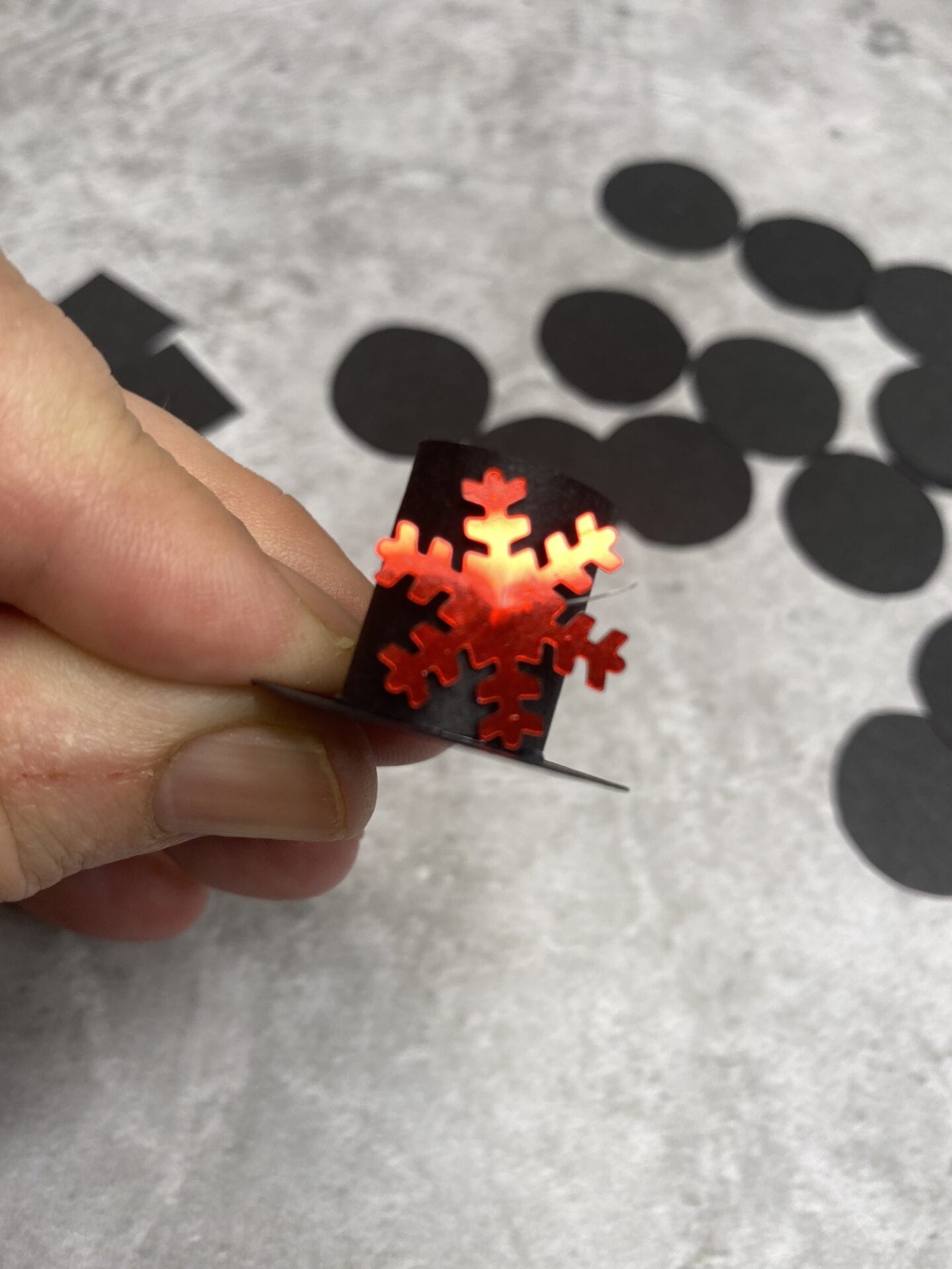 A small top hat made from card with a red snowflake sequin stuck to the front