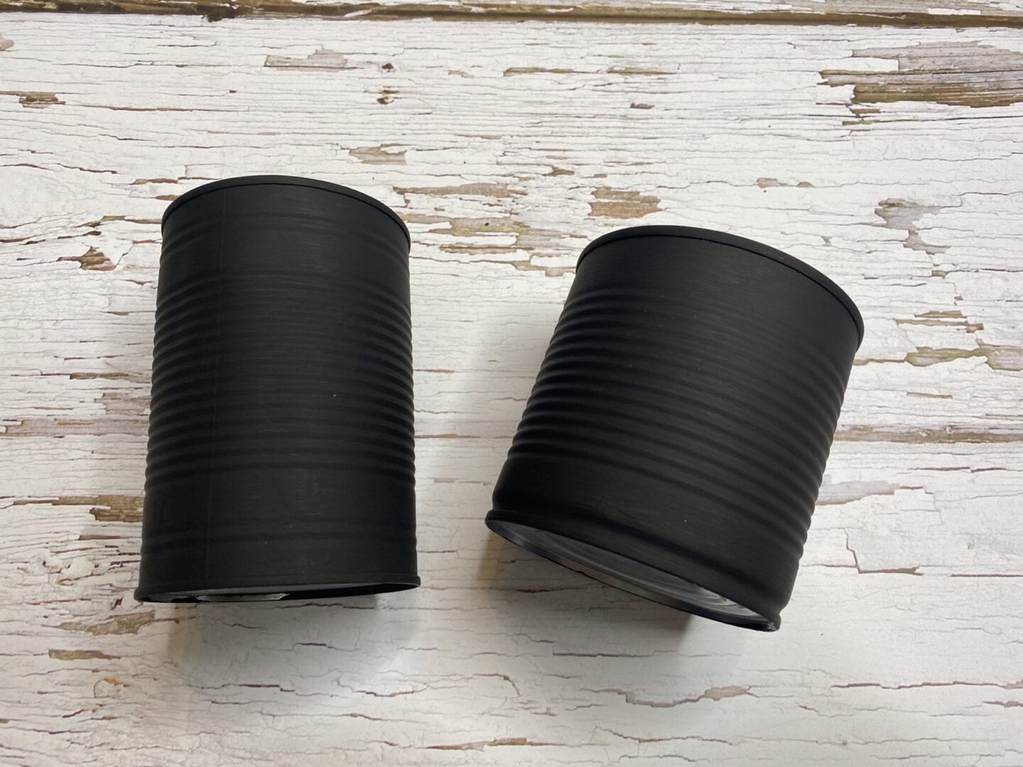 2 tin cans painted with blackboard paint